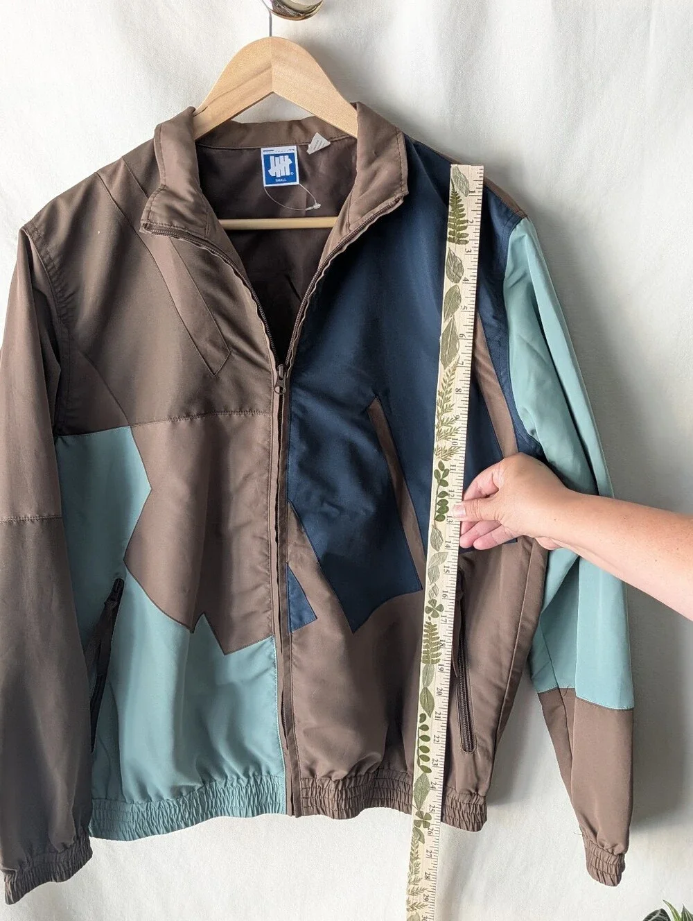 Undefeated Jacket in Taupe and Beige with Blue Logo Tag